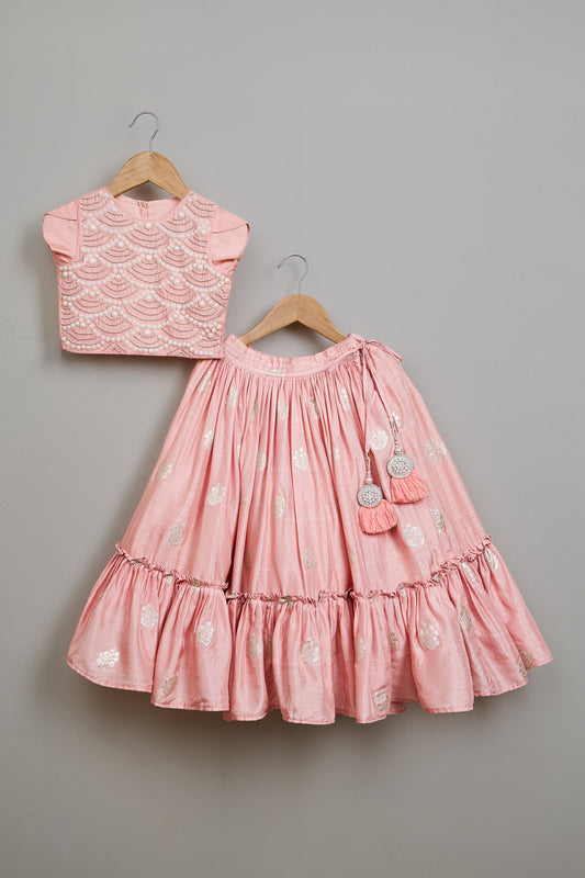 Pink dress and top set on hangers against a gray background

