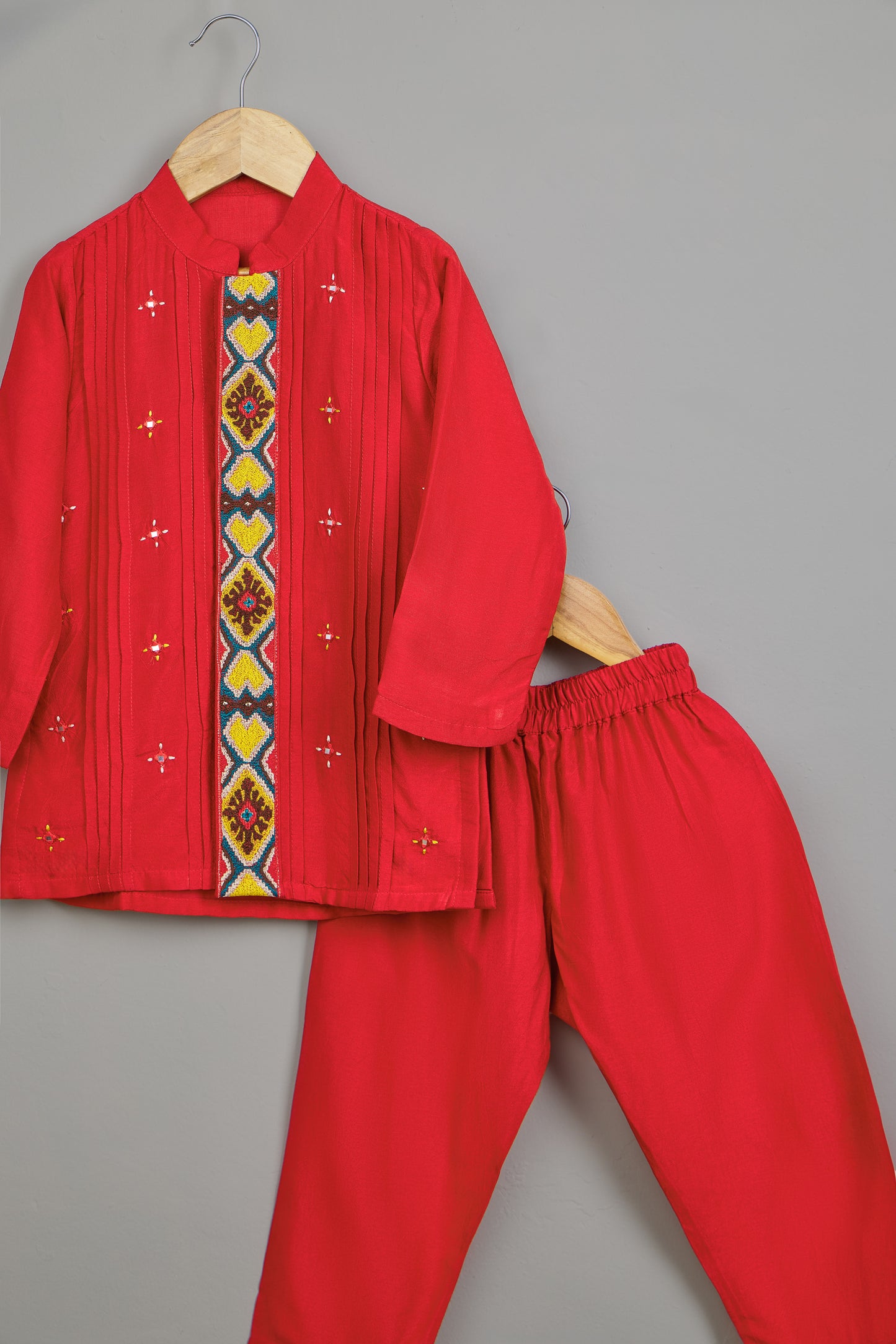 Red traditional outfit with embroidered details on a gray background